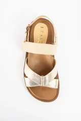Sandalias planas de cuero en color camel y dorado, con suela track marrón y tiras cruzadas en la parte delantera. Cuentan con tira ajustable en el talón con hebilla metálica.