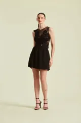 Top de mujer sin mangas color negro, con cuerpo de red transparente decorado con apliques florales bordados y abalorios.