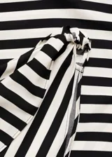 Vestido largo de fiesta con diseño entallado y escote asimétrico de un solo hombro. Presenta un estampado de rayas diagonales en blanco y negro, con un detalle de nudo en el tirante.
