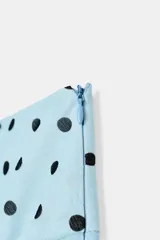 Falda midi de tiro medio color celeste con estampado de lunares negros, diseño asimétrico y forro interior. Cuenta con cierre lateral de cremallera oculta.