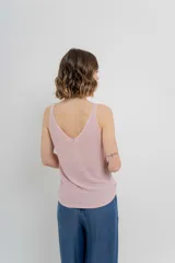 Musculosa tejida color amarillo pálido, con escote en V delantero y trasero.