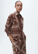 Camisa marrón con estampado paisley, de corte recto, cuello camisero y mangas largas con puños abotonados.