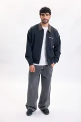 Pantalón de jean estilo skater color gris claro, de corte amplio y relajado, con bolsillos laterales grandes.