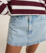 Short pollera de jean celeste con tiro alto, bolsillos delanteros y traseros, y trabillas en la cintura.