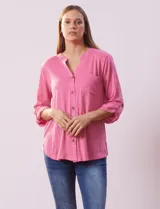 Blusa Ninety color beige con textura, cuello base con escote en V y abertura central con botones. Tiene un bolsillo en el pecho y mangas 3/4 regulables con presilla y botón.