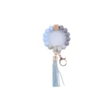 Llavero con pulsera de cuentas redondas de silicona en tonos celeste y gris, con un cubo de madera natural y borla decorativa en color celeste.