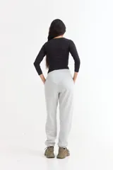 Pantalón jogger de felpa color marrón, con cintura elástica ajustable mediante cordón, bolsillos laterales y puños elásticos en los tobillos.