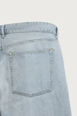 Jeans de corte recto color celeste claro, con tiro medio, diseño de cinco bolsillos, efecto lavado y bajo con acabado irregular deshilachado.