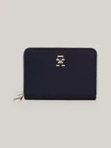 Billetera mediana de Tommy Hilfiger en color azul marino, con cierre de cremallera perimetral. Presenta el monograma TH metálico en dorado en la parte frontal y un tirador de cierre con los colores distintivos de la marca.