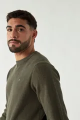 Sweater azul marino de punto con cuello redondo, mangas largas y logo bordado en el pecho.