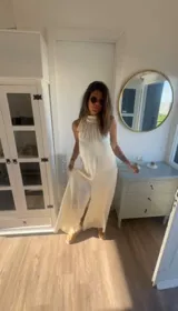 Mono largo de satén color blanco, con cuello halter y diseño amplio de pierna ancha.