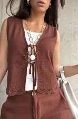 Chaleco marrón de lino liviano con bordado en la terminación y ajuste con lazo al frente.