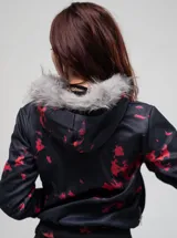 Campera con cierre frontal, confeccionada en poliéster con estampado gráfico tipo camuflado y tipografía. Presenta capucha con borde de piel sintética no removible y ajuste regular.
