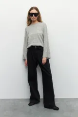 Jean ancho de algodón color negro, con pretina ancha, pinzas delanteras y bolsillos laterales.