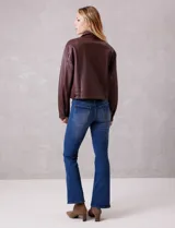 Campera de eco cuero color bordó, con cuello camisero, cierre frontal metálico y bolsillos laterales. Presenta un diseño de corte recto y forro interno a tono.