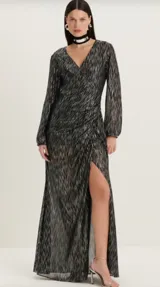Vestido largo negro con estampado de líneas plateadas, escote en V cruzado, mangas largas abullonadas y abertura lateral en la falda.