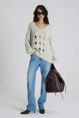 Sweater calado color verde claro de algodón moulinado, con escote en V y silueta holgada.