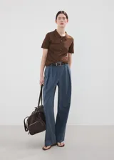 Chaleco de punto fino color marrón, de diseño recto, con cuello polo, mangas cortas y cierre delantero de botones.