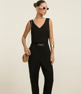 Pantalón negro de corte zanahoria, con cintura elástica, adorno metalizado en la cintura y bolsillos laterales.