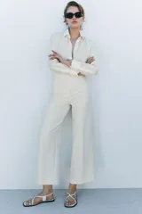 Pantalón tipo culotte de tiro alto, pierna ancha y pinzas frontales. Color beige/topo liso.