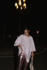 Pantalón de ecocuero con acabado metalizado en color rosado, de corte capri semi oxford y tiro medio-alto. Presenta cierre frontal con botón metálico y bolsillos traseros.