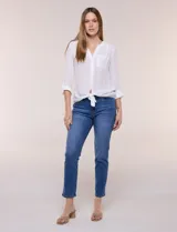 Blusa de calce relajado color salmón, confeccionada en tela liviana con textura sutil. Presenta escote en V con abotonadura frontal, bolsillo parche en el pecho, mangas largas regulables con presilla y ruedo con opción de anudar en el frente.