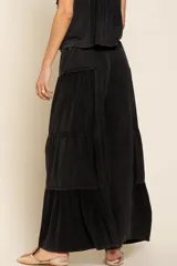 Pantalón negro de tela acanalada con diseño de paneles horizontales que crean un efecto de volados. Presenta corte amplio, cintura elástica con cordón de ajuste y caída fluida.