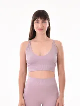 Top deportivo lila oscuro, de tejido acanalado y breteles finos cruzados en la espalda.