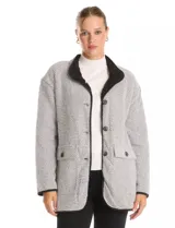 Cardigan de corte recto con diseño de espiga en tonos gris y blanco. Presenta cuello solapa, cierre frontal con botones y bolsillos tipo parche con solapa. El interior está forrado en corderito sintético negro, con vivos en contraste en los bordes.