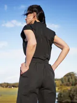 Mono color arena de lino, con cuello mao, cierre frontal con cremallera, mangas cortas y cinturón de lazo.