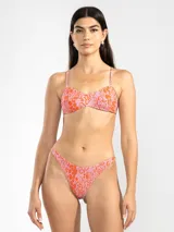 Bikini de dos piezas con estampado animal print en tonos rosado y naranja. El corpiño es de breteles finos y se ata en la espalda. La bombacha es de tiro bajo con cobertura mínima.