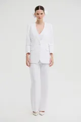 Pantalón de vestir blanco de corte recto y silueta amplia con caída fluida.