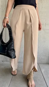 Pantalón color beige de corte palazzo con abertura lateral en la parte inferior de la pierna.