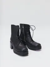Bota de cuero tipo borceguí con cordones, cierre lateral metálico y taco cuadrado alto con plataforma. Presenta punta cuadrada y diseño robusto.