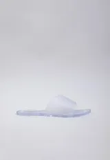 Sandalia chata de goma semi transparente con tira ancha sobre el empeine.