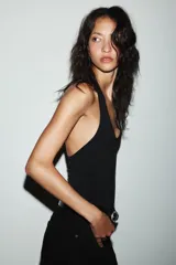 Body de cuello halter confeccionado en tejido rib, con diseño de espalda descubierta y cierre inferior.