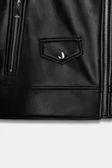 Cazadora biker negra de efecto piel, con cuello solapa, manga larga y cremalleras metálicas. Presenta bolsillos delanteros con cierre de cremallera y cierre frontal cruzado con cremallera.