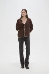 Cardigan de viscosa color marrón, con cuello en V, cierre frontal con botones y detalle de costura decorativa en contraste a lo largo de los bordes.