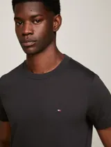 Remera negra de algodón elástico con corte slim fit, cuello redondo y logo de Tommy Hilfiger bordado en el pecho.