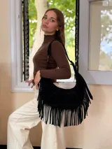 Cartera tipo hobo de cuero negro con diseño de flecos largos en los laterales. Cuenta con una correa de hombro integrada y cierre superior.