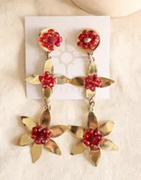 Aros colgantes dorados con forma de flor, decorados con cuentas rojas.