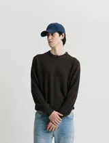 Sweater de punto con escote redondo, confeccionado en algodón con textura de punto fantasía en cuerpo y mangas, y terminaciones en punto canalé en cuello y puños.