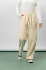 Pantalón deportivo de corte wide leg con caída relajada. Presenta cintura elastizada con cordón ajustable, bolsillos laterales y un interior frizado para mayor abrigo.