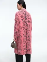 Saco largo de tejido de punto con textura peluda, estampado de cebra en tonos rosa y negro, con cierre frontal de un botón y capucha integrada.