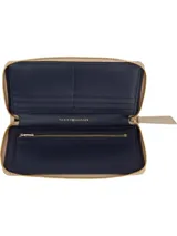 Billetera Tommy Hilfiger color beige con diseño acolchado a rombos y logo TH metálico en el frente. Cierre con cremallera y forro interior de poliéster.