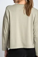 Remera color verde oliva de algodón peinado, corte oversize y mangas largas.