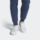 Championes Adidas modelo Superstar, de diseño clásico en color blanco total, con la icónica puntera de goma y las tres bandas laterales perforadas.