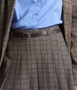 Short pollera de sastre con diseño de cuadros, presenta pliegues marcados y cintura recta. Incluye un cinturón ajustable con hebilla metálica y cuenta con estructura de short por debajo.