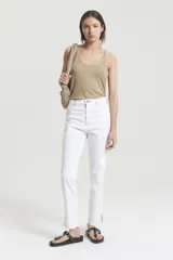 Pantalón de jean blanco, corte mom fit, tiro alto y costuras color camel a contratono.