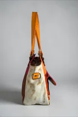 Cartera de cuero multicolor de diseño artesanal e intervenida con arte, modelo Lira de la Línea Dubai, con doble asa de hombro y bolsillo frontal con solapa pintada.